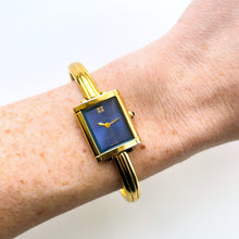 Load image into Gallery viewer, Vintage 90s Yves Saint Laurent Ladies&#39; Bangle Style Quartz Watch with Gold-Tone Bracelet and Metallic Blue Dial
