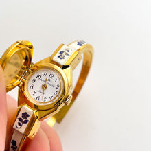 Load image into Gallery viewer, Vintage André Mouche Quartz Watch with Beige and Blue Enamel Floral Design, Concealed Dial and Gold-Plated Bangle Bracelet
