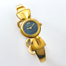 Load image into Gallery viewer, Vintage 1990s Gold-Plated Ladies&#39; Nina Ricci Bangle Quartz Watch with Ribbon Design and Small Blue Dial
