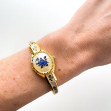 Load image into Gallery viewer, Vintage 00s André Mouche Quartz Watch with Beige and Blue Enamel Floral Design, Concealed Dial and Gold-Plated Bangle Bracelet - Boxed
